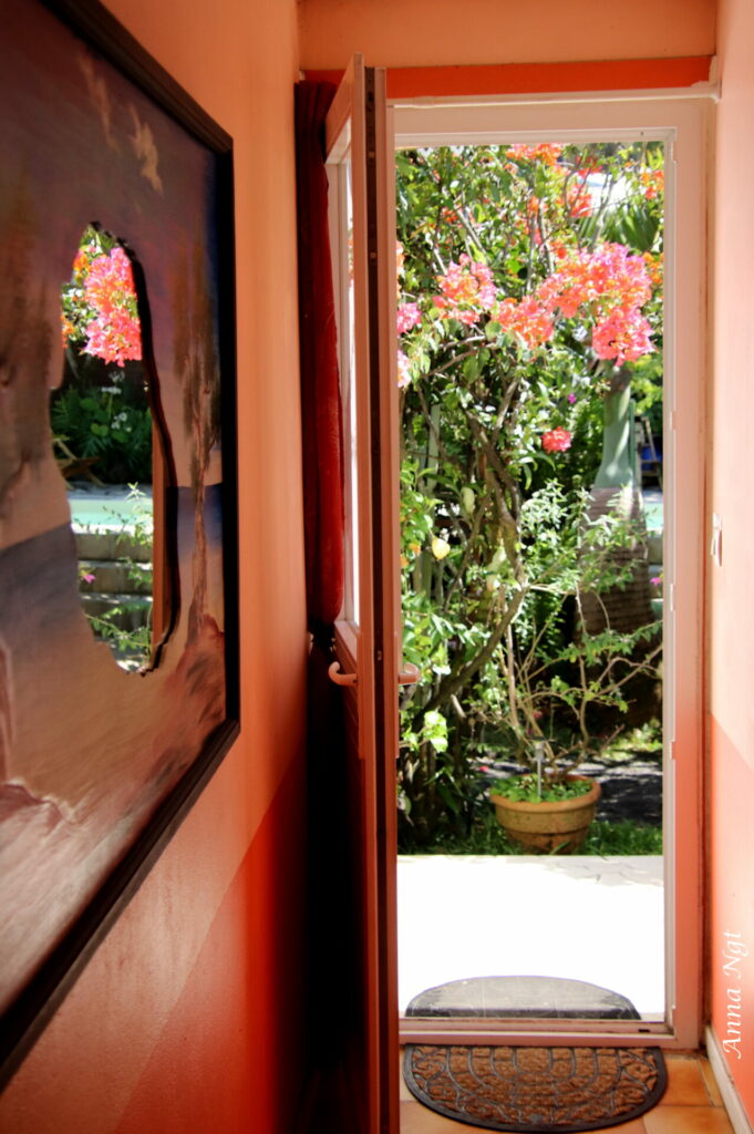 La porte d’une chambre ouverte sur le jardin fleuri de bougainvilliers